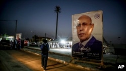FILE - An electoral banner for Mauritanian president Mohamed Ould Ghazouani is placed during a campaign rally, ahead of the presidential elections in Nouakchott, June 26, 2024. 