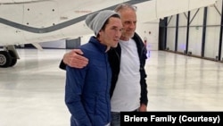 This handout photo released by Blandine Briere shows French-Irish citizen Bernard Phelan, right, and French citizen Benjamin Briere upon their arrival at Le Bourget Airport near Paris on May 12 after their release from Iran. (AFP PHOTO/BRIERE FAMILY )