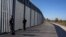 FILE - Police border guards patrol along a border wall near the town of Feres, along the Evros River which forms the the frontier between Greece and Turkey, Oct. 30, 2022. 