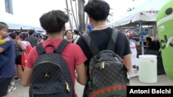 Dos jóvenes de ascendencia cubana caminan por un centro de distribución de útiles escolares en la ciudad de Hialeah, en Florida, EEUU.