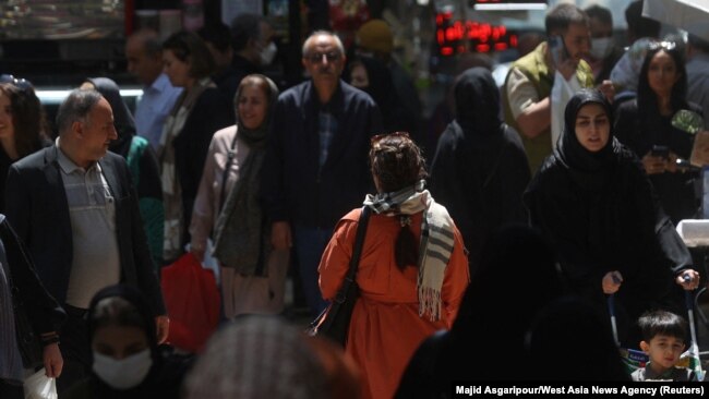 Iranians walk on a street amid the implementation of the new hijab surveillance in Tehran, Iran, April 15, 2023. Even though women can be arrested if they are not wearing a hijab in public, some are seen not wearing head coverings as they move about the community. (Majid Asgaripour/West Asia News Agency via Reuters)