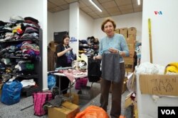 Dos voluntarias organizan la ropa que llega a este centro de ayuda a evacuados en Jerusalén.