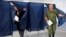 A woman and a serviceman leave a voting area at a polling station during Russia-organized elections in Donetsk, capital of Ukraine's mostly Russian-occupied Donetsk region, Sept. 10, 2023. 