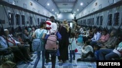 সুদানের ওয়াদি সিডনা বিমান ঘাঁটি থেকে সরিয়ে নেওয়ার সময় একটি আরএএফ বিমানে জড়ো হচ্ছে বিভিন্ন দেশের লোকজন৷ ২৮ এপ্রিল, ২০২৩। 