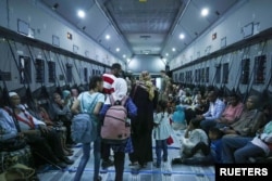 Families gather aboard an RAF plane during the evacuation from Wadi Seidna Air Base, Sudan April 28, 2023 in this handout image.