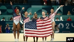 Simone Biles, center, and her teammates celebrate after Team USA won the artistic gymnastics women's team final during the Paris 2024 Olympic Games at the Bercy Arena in Paris, on July 30, 2024. 