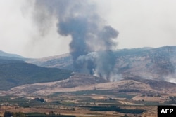 Api dan asap mengepul setelah roket yang diluncurkan dari Lebanon selatan menghantam wilayah di Israel utara, 4 Juli 2024. (Jalaa MAREY / AFP)