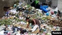 Una mujer busca comida en el basurero del centro de alimentos la Terminal, uno de los mercados de alimentos más grandes de la Ciudad de Guatemala, el 27 de febrero de 2015.