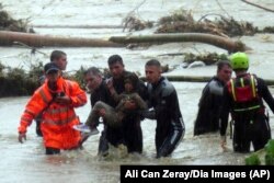 Emergency team members rescue a young girl during floods in a campsite in Kirklareli province, Turkey, Sept. 5, 2023.