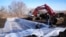FILE - Workers prepare to install wood chips in a bioreactor trench in a farm field, March 28, 2023, near Roland, Iowa. Systems called bioreactors and streamside buffers help filter nitrates from rainwater before it can reach streams and rivers. 