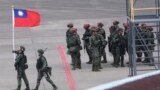 在台北桃園國際機場參加年度漢光軍演的一名士兵手持台灣旗幟。(2023年7月26日)