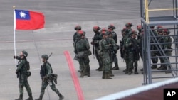 在台北桃園國際機場參加年度漢光軍演的一名士兵手持台灣旗幟。(2023年7月26日)