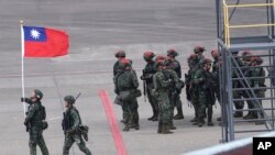 台灣軍人在年度漢光演習中模擬敵軍(帽子上有紅色標記者)襲擊桃園機場跑道。(2023年7月26日)