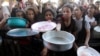 Palestinian children gather to receive food cooked by a charity kitchen, amid food scarcity, as Israel-Hamas conflict continues, in the northern Gaza Strip, July 18, 2024. 