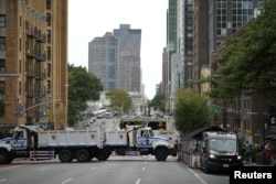 Police vehicles block access to a building as activists mark the start of Climate Week in New York during a demonstration calling for the U.S. government to take action on climate change and reject the use of fossil fuels in New York City, Sept. 17, 2023.