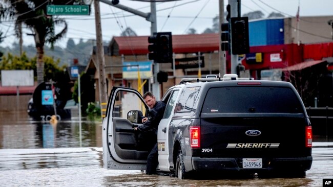 Un ayudante del alguacil revisa su camioneta mientras conduce a través de las inundaciones en la comunidad de Pájaro en el condado de Monterey, California, el lunes 13 de marzo de 2023. (Foto AP/Noah Berger)