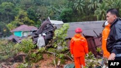 Tim penyelamat memeriksa kerusakan dan mencari korban setelah tanah longsor di kepulauan Natuna. (Foto: via AFP)