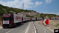 FILE - Trucks with humanitarian aid for Artsakh sit parked in a road toward the separatist region of Nagorno-Karabakh, in Armenia, July 28, 2023.