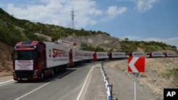 FILE - Trucks with humanitarian aid for Artsakh are parked in a road towards the separatist region of Nagorno-Karabakh, in Armenia, July 28, 2023.