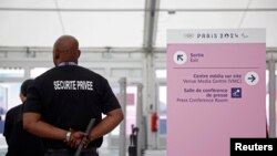 FILE - Seorang petugas menjaga keamanan di pintu masuk ruang pers di Desa Atlet Olimpiade dan Paralimpiade Saint-Denis, Prancis, 16 Juli 2024. (REUTERS/Benoit Tessier)