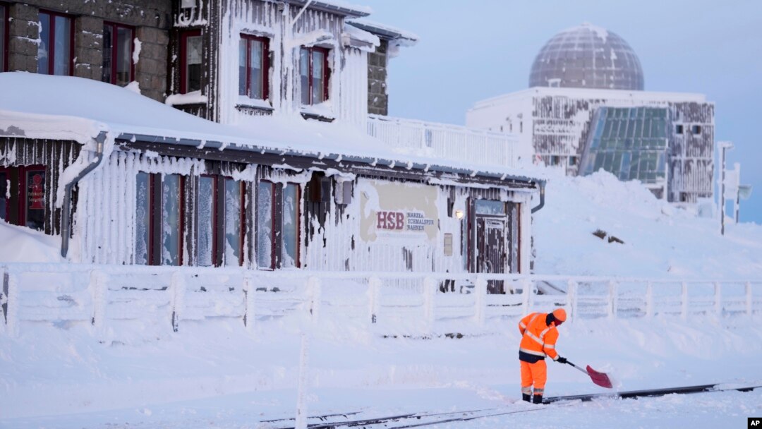 Seorang pekerja membersihkan jalur kereta api di tengah badai salju di di pegunungan Harz dekat kota Schierke, Jerman, Rabu, 17 Januari 2024.