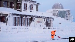 Seorang pekerja membersihkan jalur kereta api di tengah badai salju di di pegunungan Harz dekat kota Schierke, Jerman, Rabu, 17 Januari 2024.