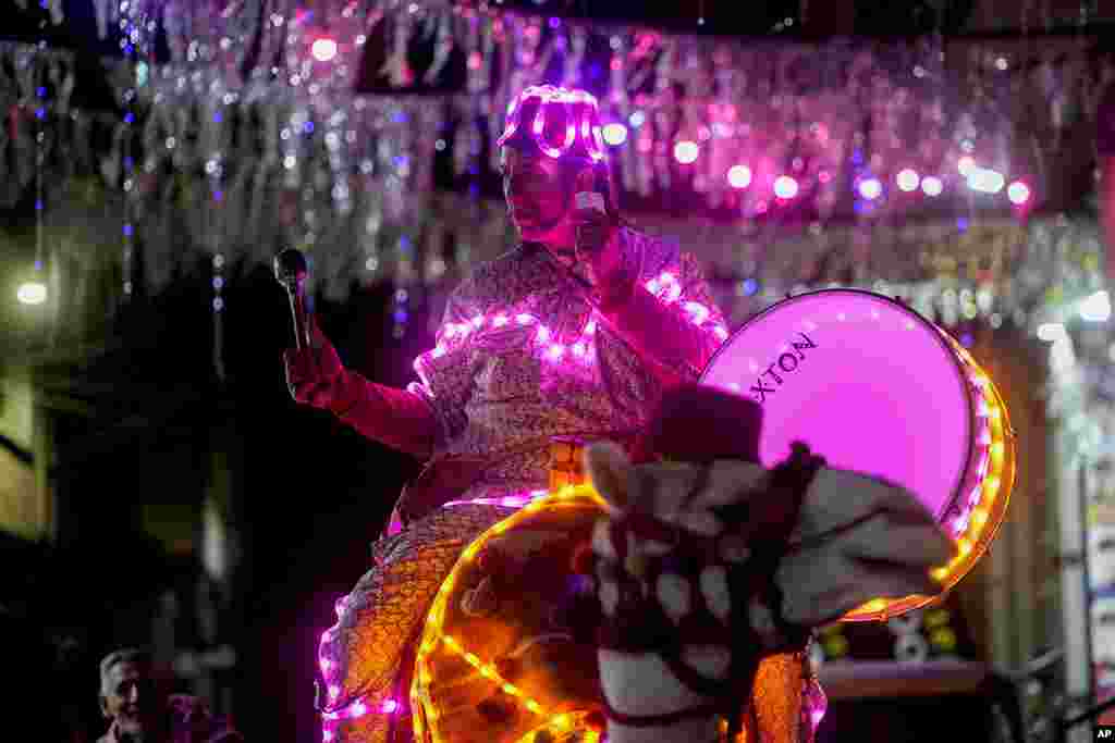 Mohammed El-Dahshan, 39-year-old "Mesaharati," or dawn caller, rides his camel wrapped with colored lights to wake up Muslims for a meal before sunrise, during the Islamic holy month of Ramadan, in the Delta city of Dikernis, Egypt.