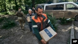 FILE - Volunteers carry humanitarian aid to residents of Chasiv Yar in Ukraine's Donetsk region, May 16, 2023. Two foreign aid workers of the Road to Relief group were reportedly killed in the area Sunday by a Russian shell.