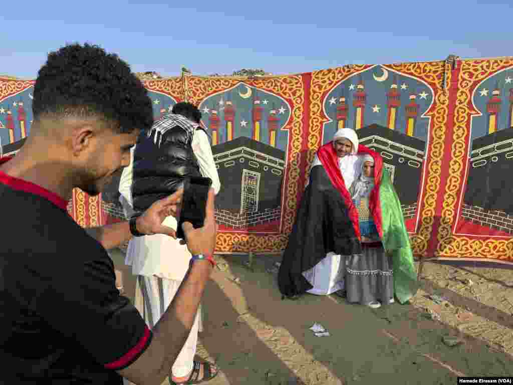 Adulrahman and his daughter Rahma pose for pictures, wrapped in a Palestinian flag. Abusir, Egypt, April 10, 2024.