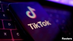 ARHIVA, ILUSTRACIJA - Logo TikToka na ekranu mobilnog telefona, ispred tastature lap topa (Foto: Reuters/Dado Ruvić)