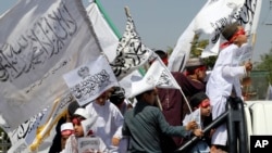 Children of Taliban fighters hold Taliban flags as they celebrate the third anniversary of the withdrawal of US-led troops from Afghanistan, in Kabul, Aug. 14, 2024. 