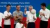 Presiden Komite Penyelenggara Paris 2024, Tony Estanguet, Presiden IOC Thomas Bach, Ketua Komisi Koordinasi Paris 2024, Pierre-Olivier Beckers-Vieujant berpose di atas panggung. (Foto: REUTERS/Benoit Tessier)