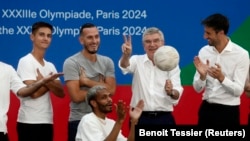 Presiden Komite Penyelenggara Paris 2024, Tony Estanguet, Presiden IOC Thomas Bach, Ketua Komisi Koordinasi Paris 2024, Pierre-Olivier Beckers-Vieujant berpose di atas panggung. (Foto: REUTERS/Benoit Tessier)