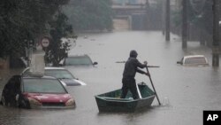 A man rows a boat on a street flooded by heavy rains, in Sao Leopoldo, Rio Grande do Sul state, Brazil, May 11, 2024. 