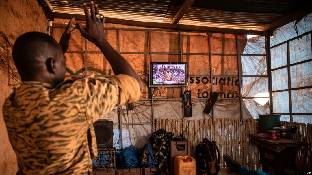 FILE - A soldier applauds the presidential inauguration of junta leader Lt. Col. Paul Henri Sandaogo Damiba during his swearing-in ceremony broadcast on national television, in Ouagadougou, Burkina Faso, Feb. 16, 2022. 