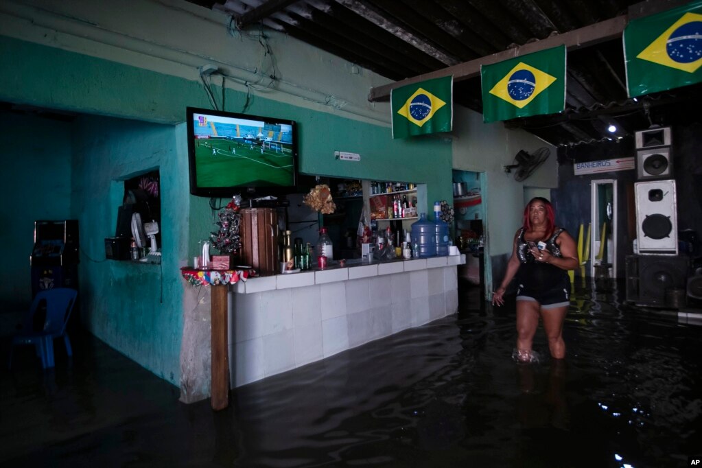  Heloisa Regina camina dentro de su bar inundado después de una lluvia mortal en Duque de Caxias, Brasil, el 14 de enero de 2024. (Foto AP/Bruna Prado).   