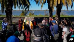 Buddhist faith leaders and community members gather at the Birthplace of Antioch marker during the "May We Gather" pilgrimage, in Antioch, California, March 16, 2024. The event aimed to use karmic cleansing through chants, prayer and testimony.