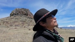 FILE - Gary McKinney, a spokesperson for People of Red Mountain and a member of the nearby Duck Valley Shoshone-Paiute Tribe, walks near Sentinel Rock on April 25, 2023, outside of Orovada, Nev. 