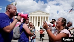 지난 24일 워싱턴 D.C. 시내 미국 대법원 청사 앞에 모인 시위대가 확성기를 든 채 임신 중절 권리 찬반 주장을 펼치고 있다. 
