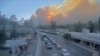 Dalam gambar yang diambil dari rekaman webcam yang disediakan oleh Desa Ruidoso, asap membubung di belakang Ruidoso, New Mexico, Senin, 17 Juni 2024. (Desa Pariwisata Desa Ruidoso via AP)