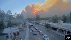 Dalam gambar yang diambil dari rekaman webcam yang disediakan oleh Desa Ruidoso, asap membubung di belakang Ruidoso, New Mexico, Senin, 17 Juni 2024. (Desa Pariwisata Desa Ruidoso via AP)