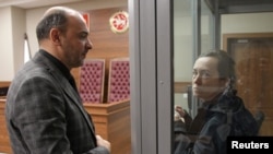 Алсу Курмашева беседует с адвокатом во время заседания суда в Казани, 23 октября 2023 года
