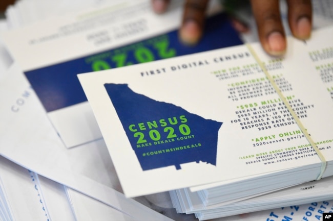 In this Aug. 13, 2019, file photo a worker gets ready to pass out instructions on how to fill out the 2020 census during a town hall meeting in Lithonia, Ga. (AP Photo/John Amis, File)