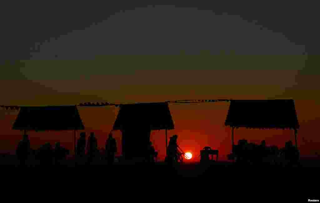 Palestinians sit at the beach during sunset in Gaza City.