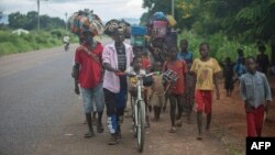 Watu waliopoteza kamazi kutoka jimbo la Cabo Delgado wakitembea katika wilaya ya Nampula February 27, 2024. Picha na Alfredo ZUNIGA / AFP.