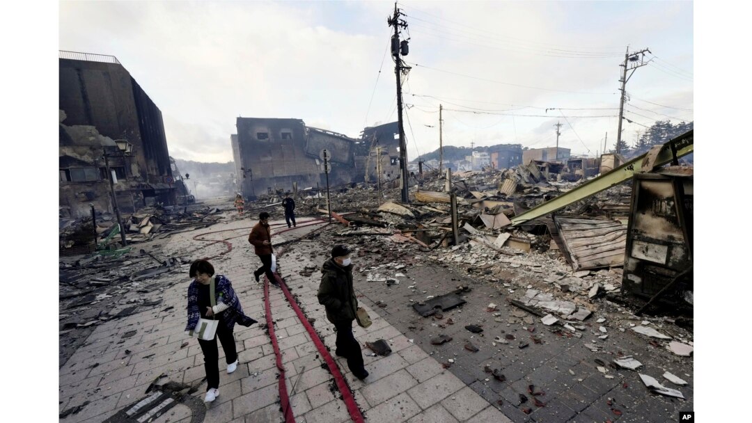 Ljudi hodaju pored objekata srušenih u zemljotresu u Vadžimi, prefektura Išikava, Japan, 2. januara 2024. (Kyodo News via AP)