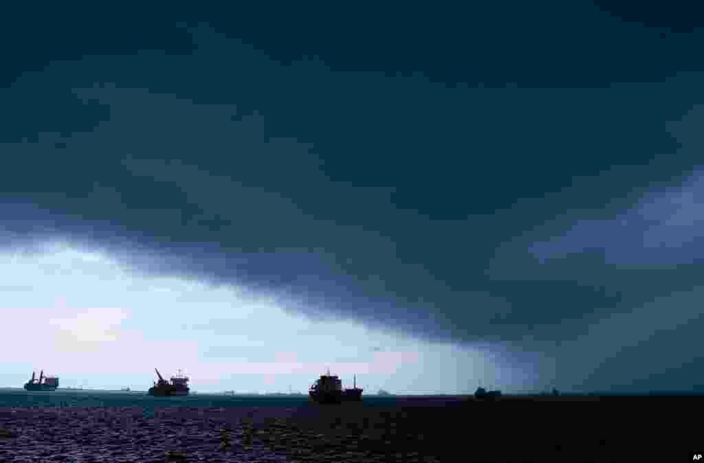 Storm clouds cover the sky as cargo ships waiting to transit through the Panama Canal are anchored on the Atlantic side of the Panama Canal, seen from Colon, Panama, Sept. 4, 2023.