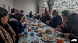 Armenians of Diyarbakir sit on an Easter celebration table set in the garden of the Armenian church Surp Giragos, in Diyarbakir, southeastern Turkey, on April 9, 2023.