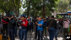 Media personnel report while standing outside a building housing BBC office in New Delhi, India, Feb. 14, 2023.