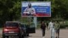 FILE - People walk near a banner in support of the Russian Army, in the town of Vyborg, Leningrad Region, Russia, May 28, 2023. The banner reads "We love you! We are proud of you! We are waiting for you with a victory!"